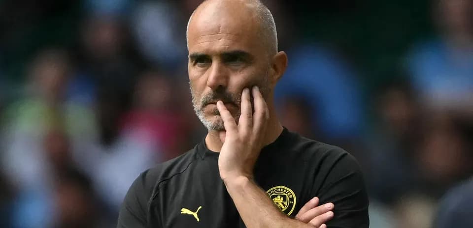 Manager observing the match with thoughtful expression