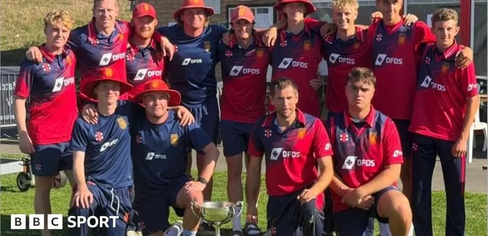 Cricket team posing with trophy outdoors