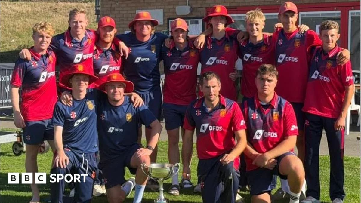 Cricket team posing with trophy outdoors