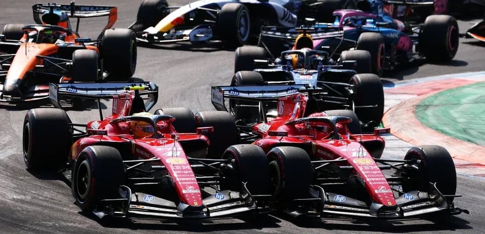 Two Ferrari cars racing closely in Formula 1 event