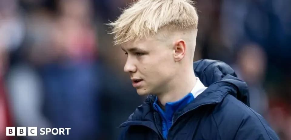 Player in club jacket walking on the sidelines