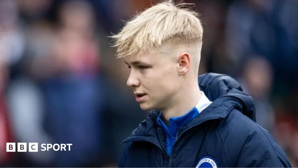 Player in club jacket walking on the sidelines
