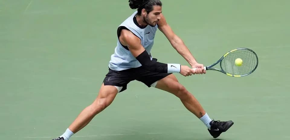 Tennis player executing a backhand stroke on court