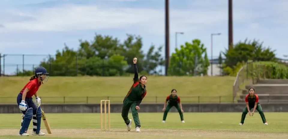 Bowler delivering ball while batter prepares to hit