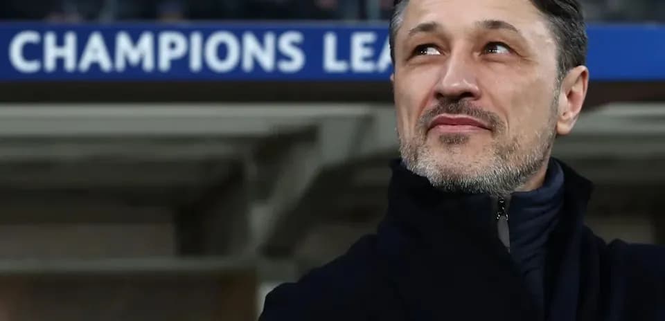Coach observing match with Champions League banner behind