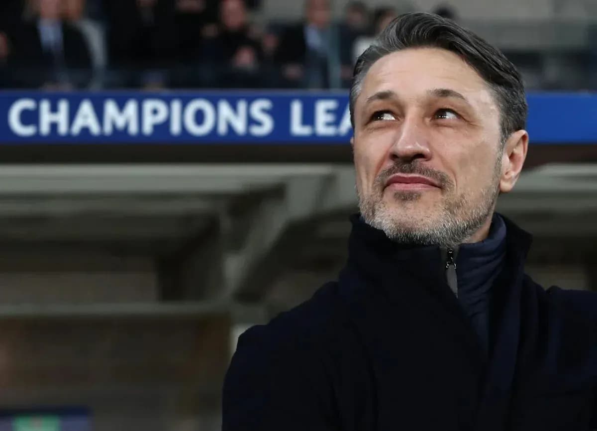 Coach observing match with Champions League banner behind