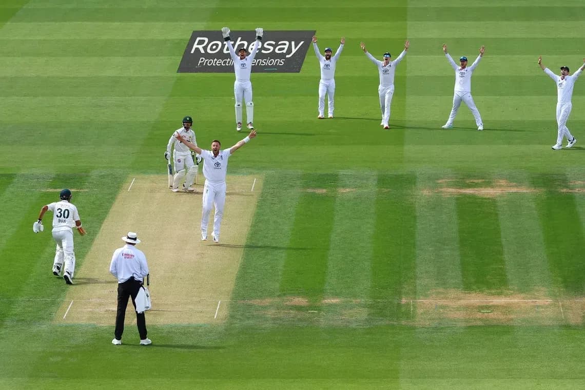 Bowler celebrating appeal with teammates during match