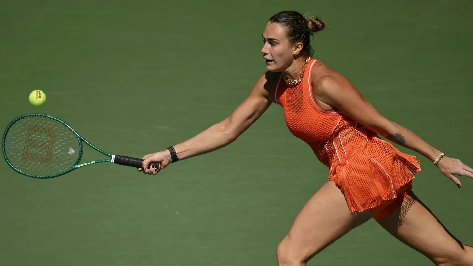 Female tennis player reaching for a flying ball