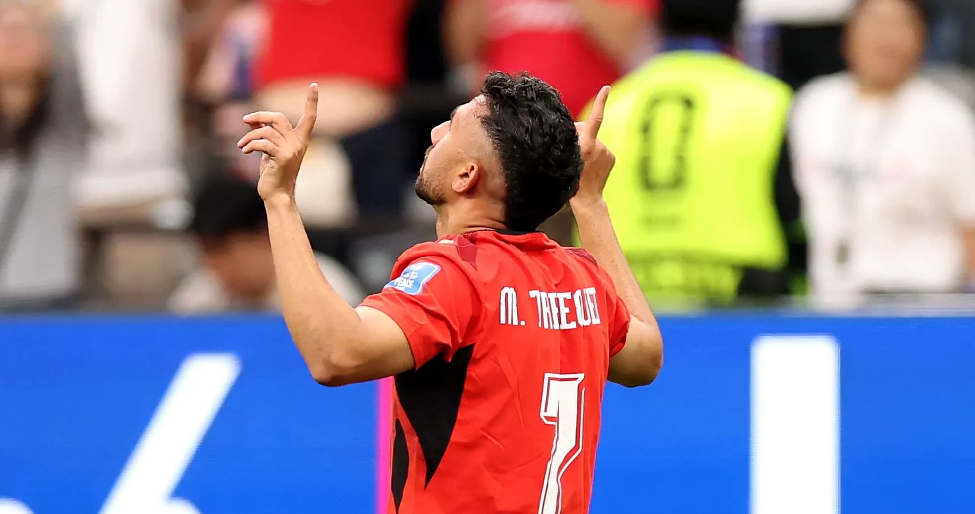 Player celebrating goal with arms raised during match
