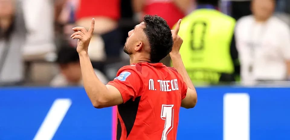Player celebrating goal with arms raised during match
