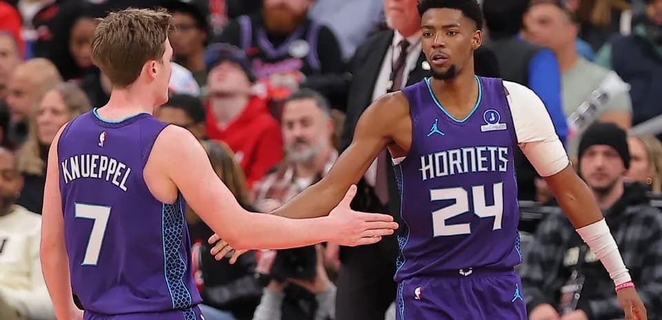 Two Hornets players greeting each other during game