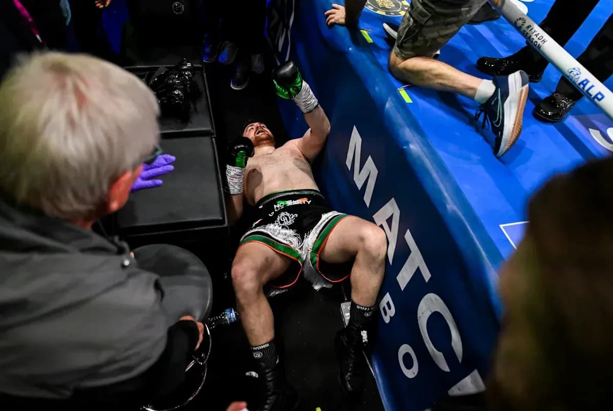 Boxer on the floor after match with corner team