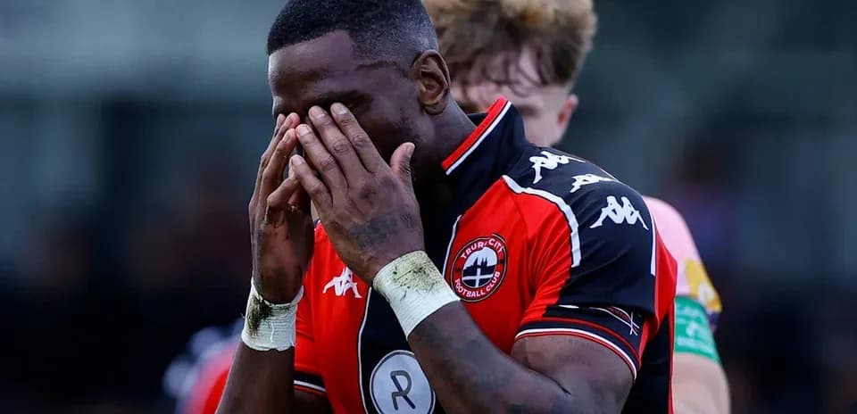Player holding head in disappointment on the field