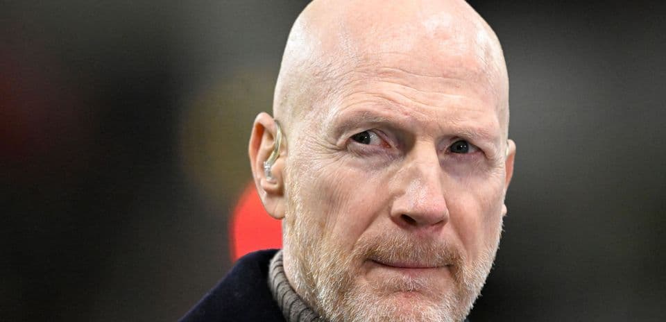 Man with a bald head and beard wearing an earpiece
