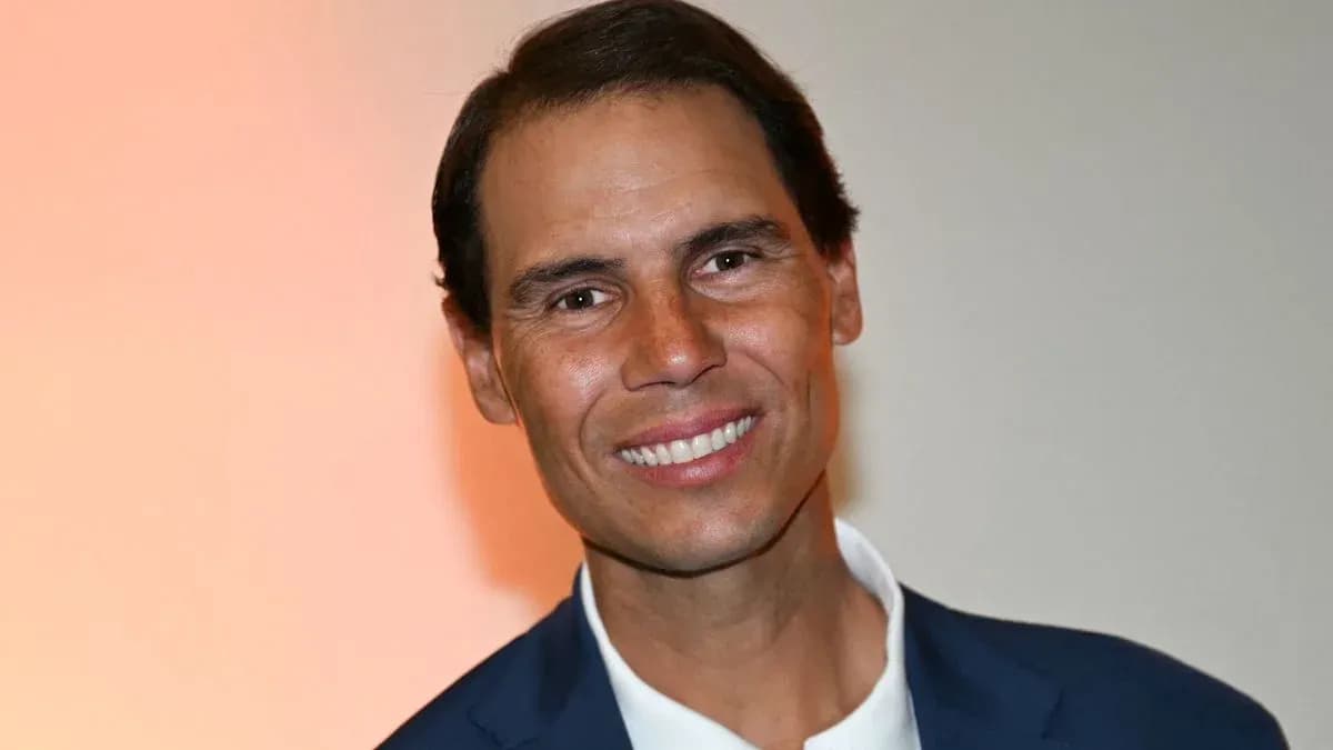 Man smiling in a suit against an orange background