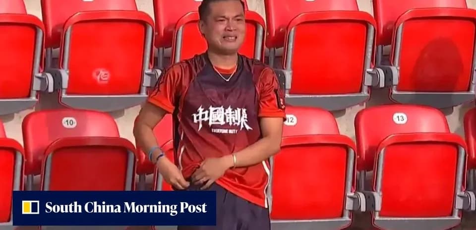 Fan in red shirt standing alone in stadium seats