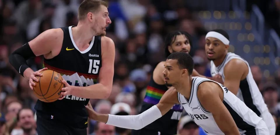 Player dribbling basketball while being guarded during game