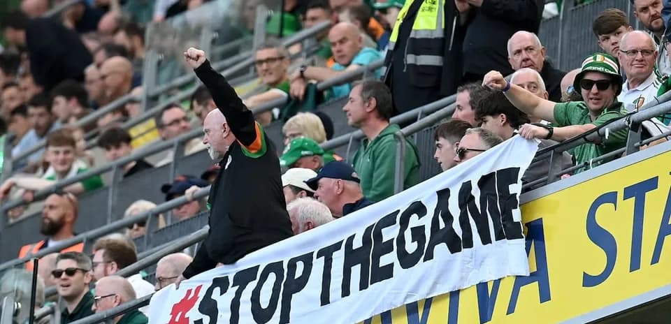 Fans holding banner and cheering in stadium stands