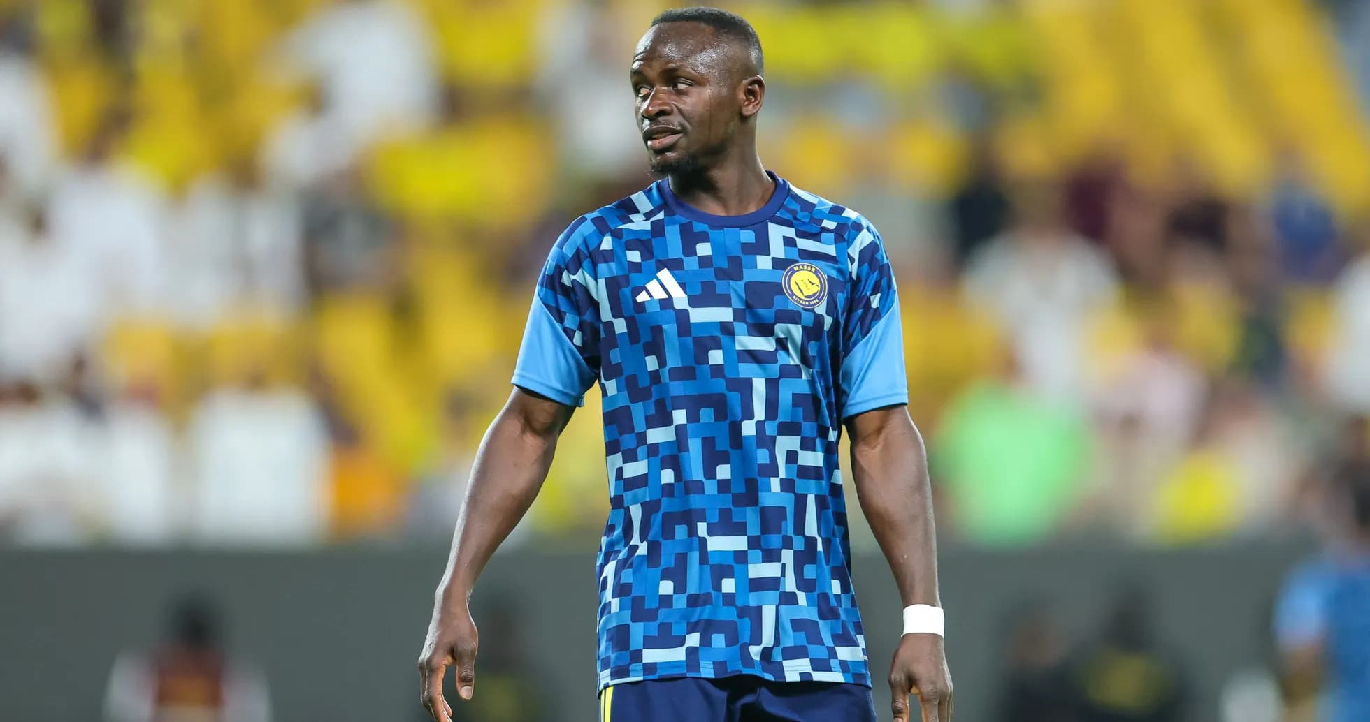Player in blue patterned jersey on the field