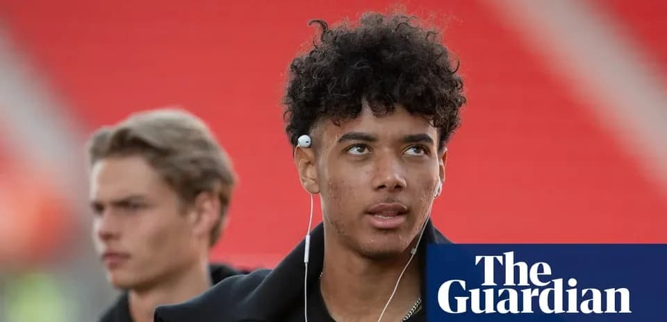 Young player with headphones walking in stadium