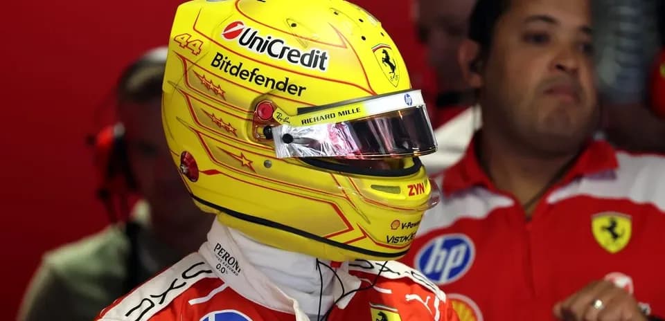Driver in Ferrari suit with helmet in garage