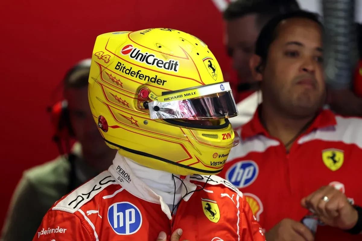 Driver in Ferrari suit with helmet in garage