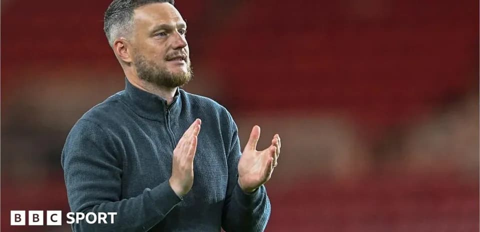 Coach applauding in a stadium setting