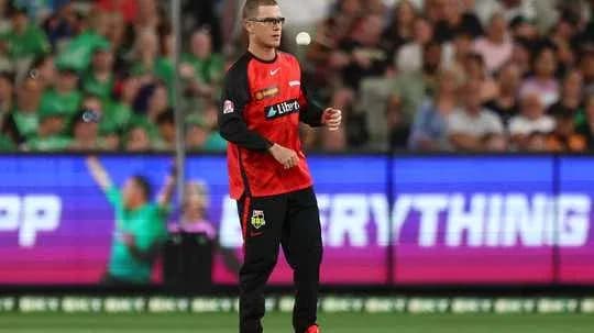 Player holding a cricket ball on field