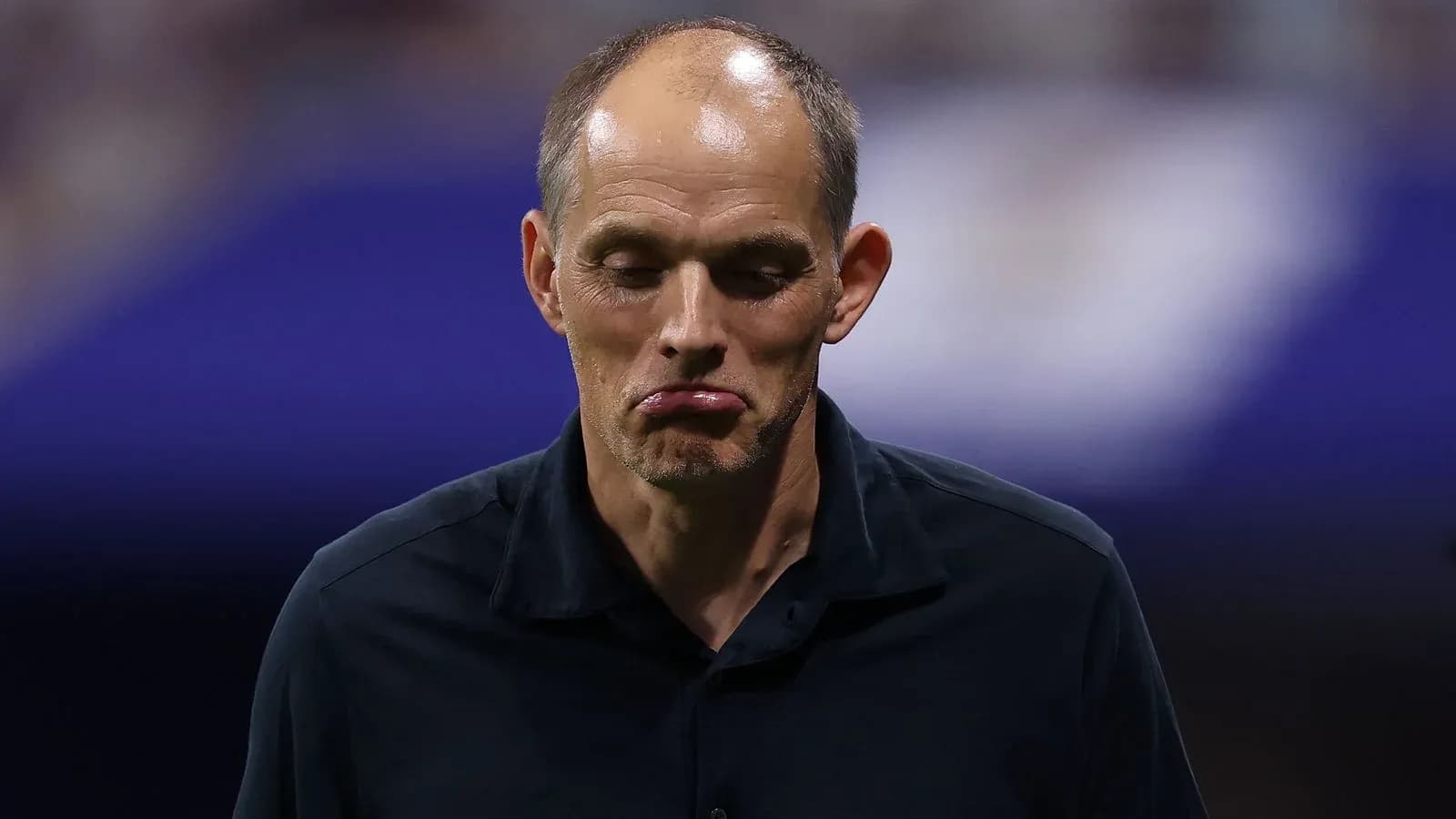 Coach looking down during match commentary