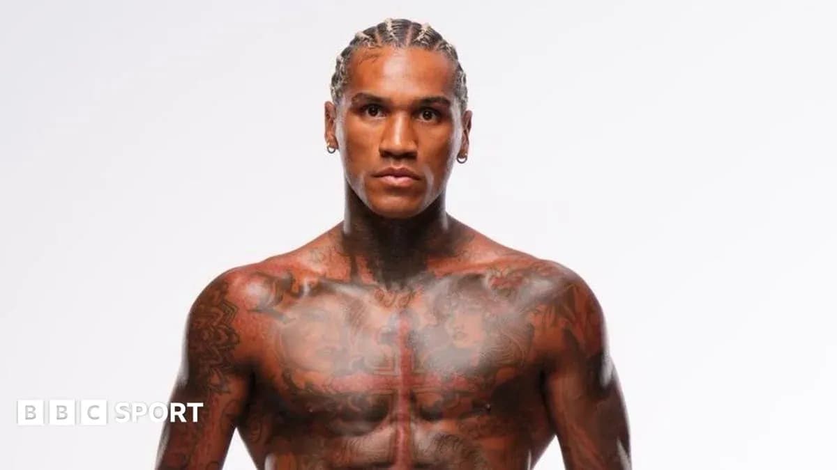 Tattooed athlete posing against a plain background
