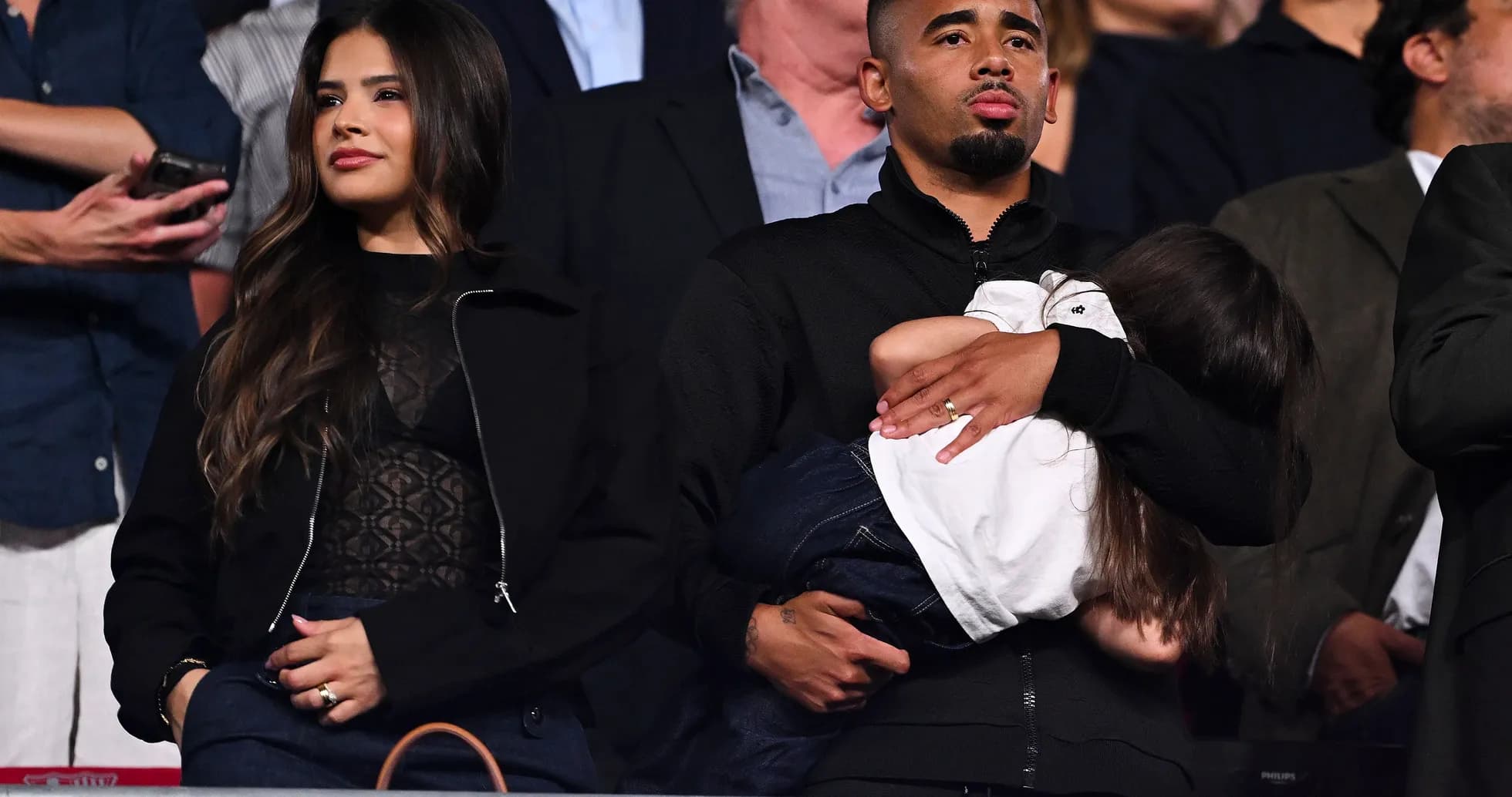 Man holding a child, woman standing beside him