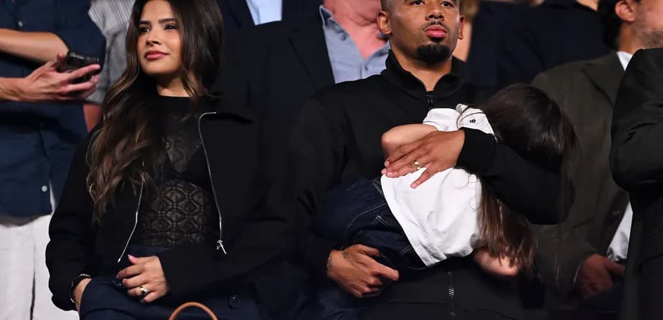 Man holding a child, woman standing beside him