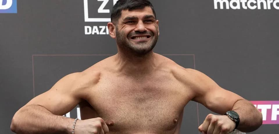 Fighter posing during weigh-in event with backdrop