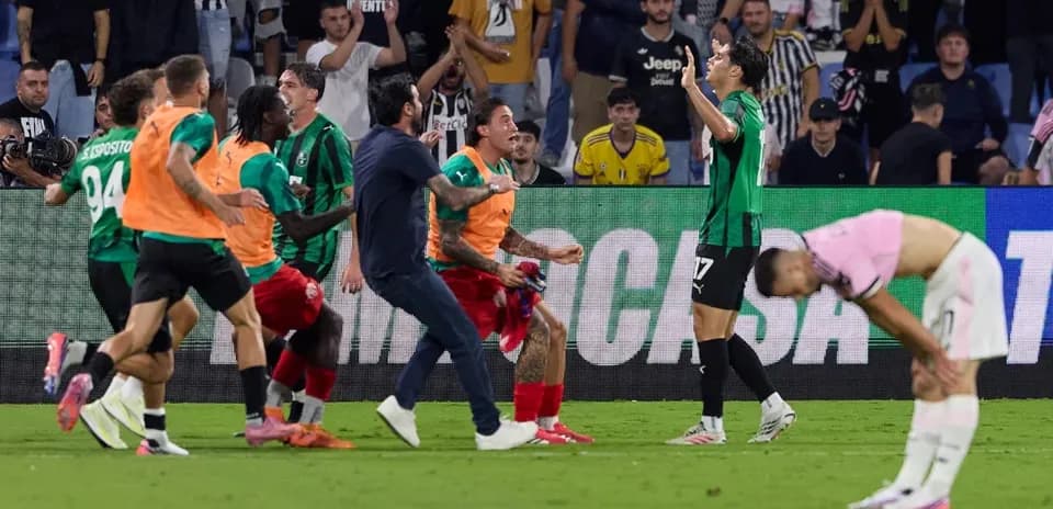 Players celebrating a goal with fans in stadium