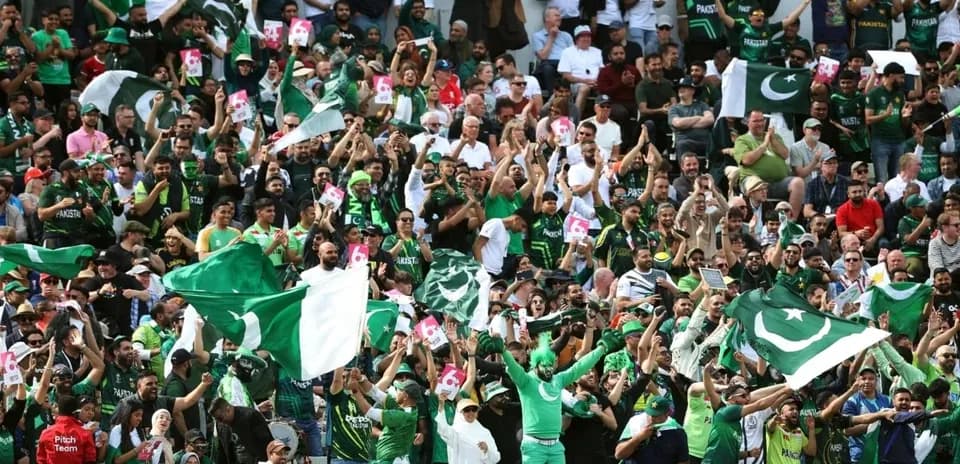 Crowd of Pakistani fans cheering with flags