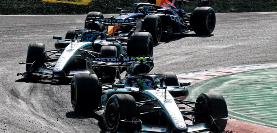 Three Formula 1 cars racing on track during competition