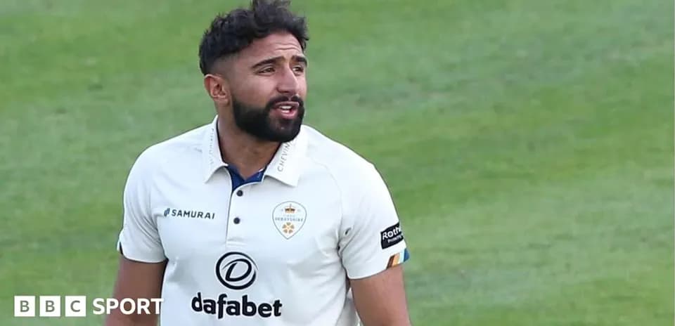 Cricketer wearing white kit on the field