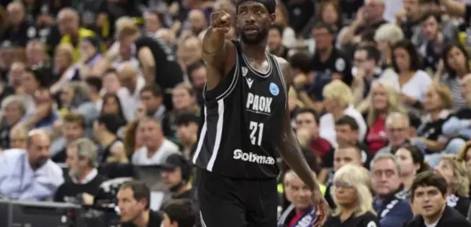 Player pointing during basketball game with crowd behind