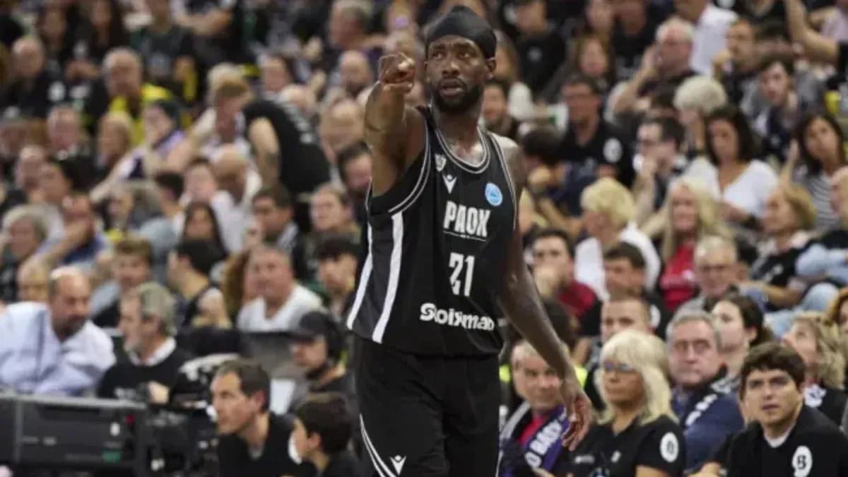 Player pointing during basketball game with crowd behind