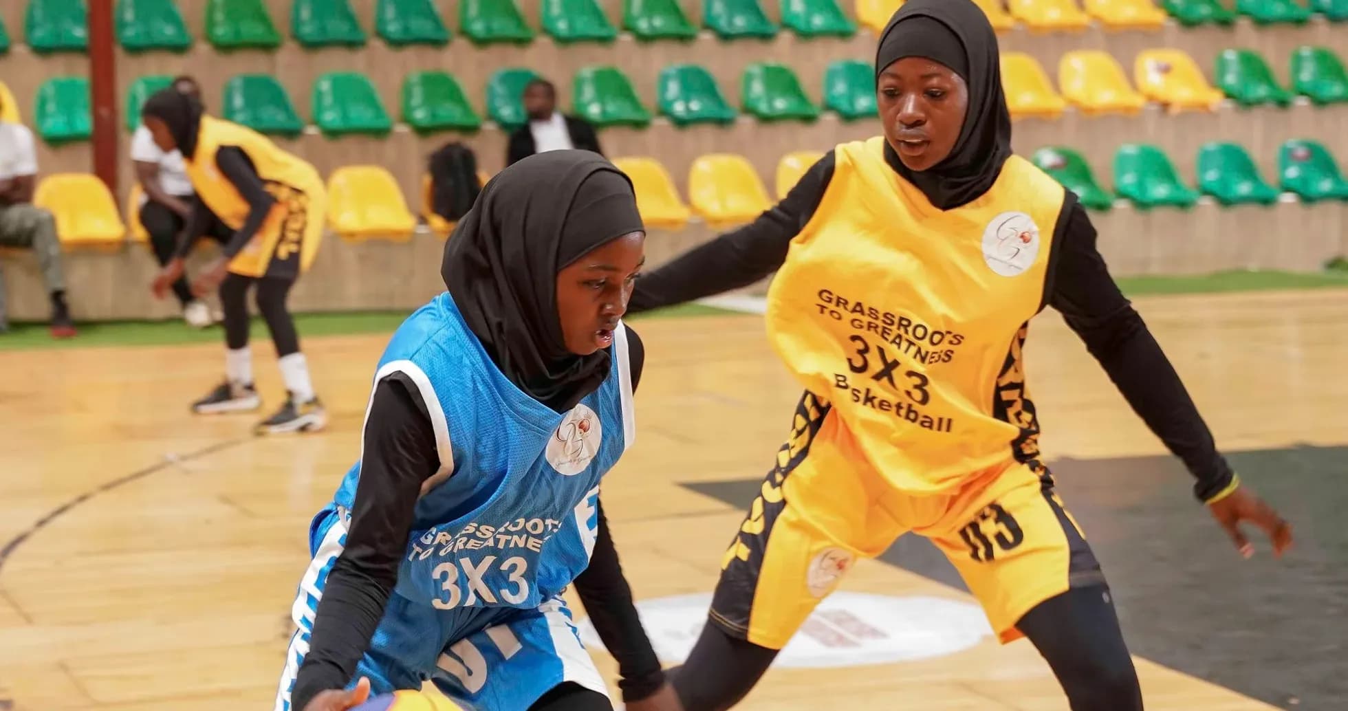 Two female players dribbling basketball during match