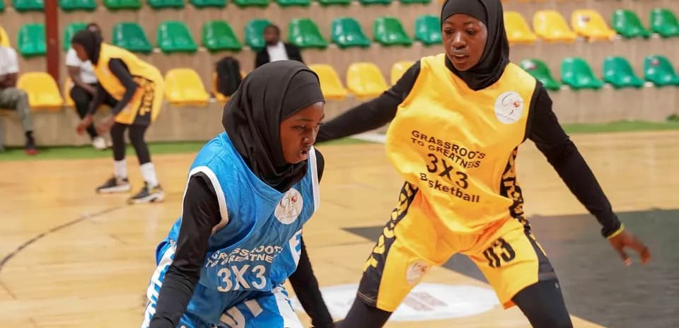 Two female players dribbling basketball during match