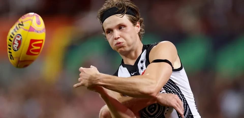 Player passing the ball during AFL match