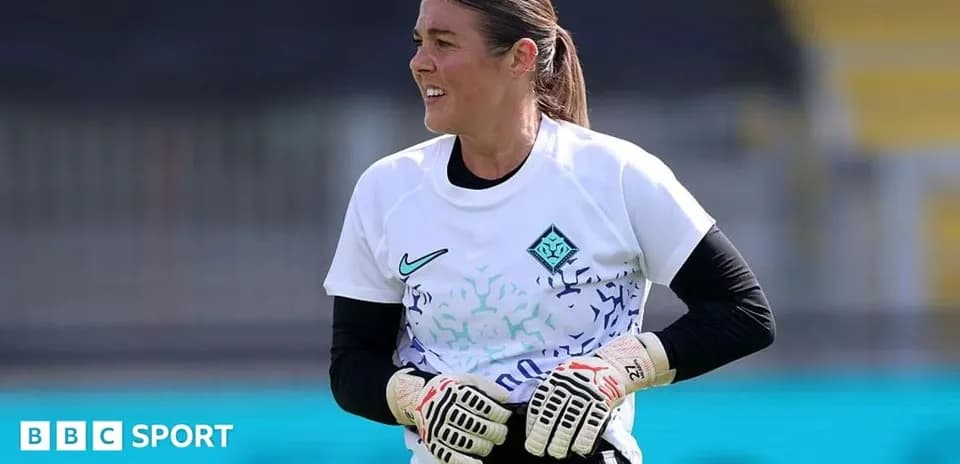 Goalkeeper in training with gloves on pitch