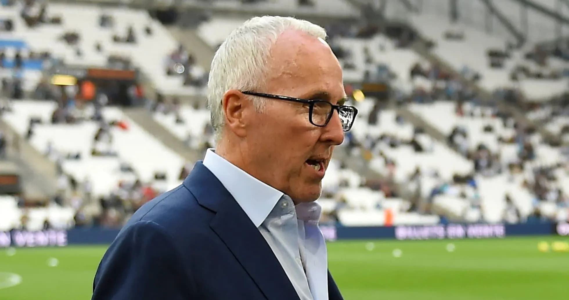 Manager walking near empty stadium before match