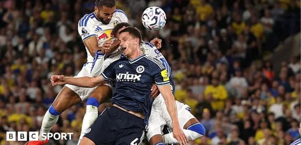 Players contesting a header during a football match