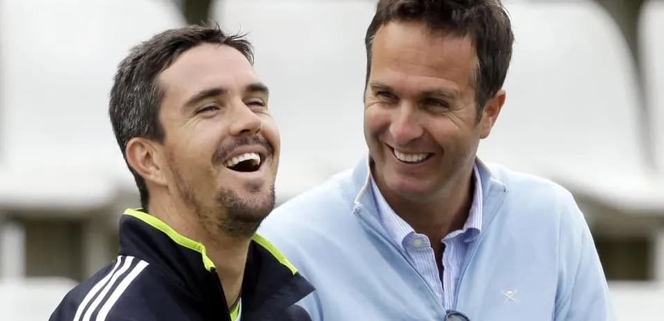 Two cricket players laughing during a casual moment