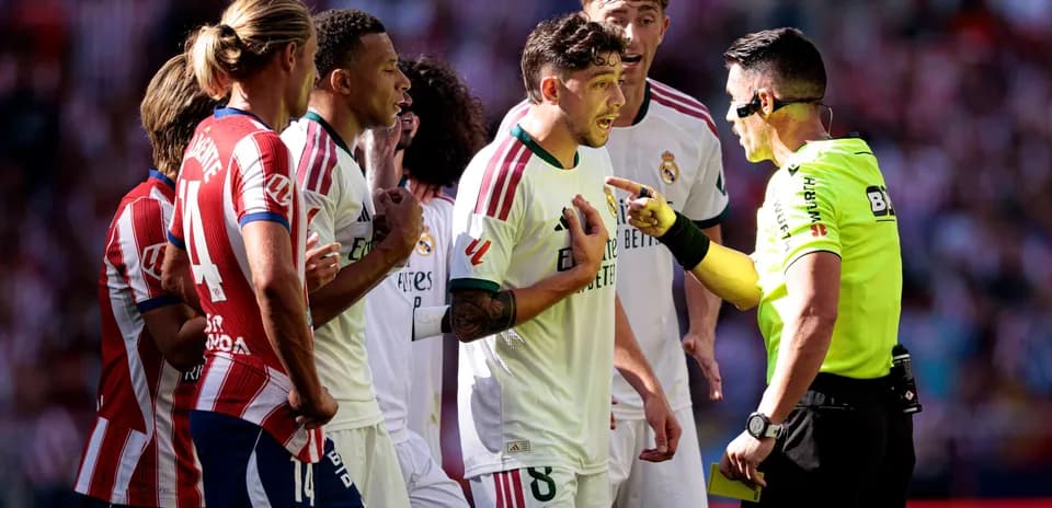 Players arguing with referee during football match