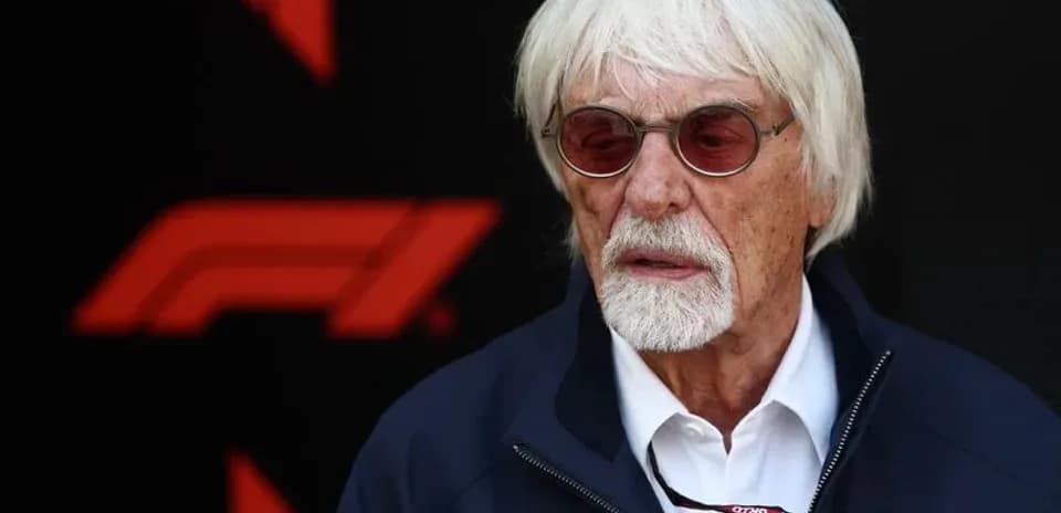 Man with white hair wearing sunglasses at event