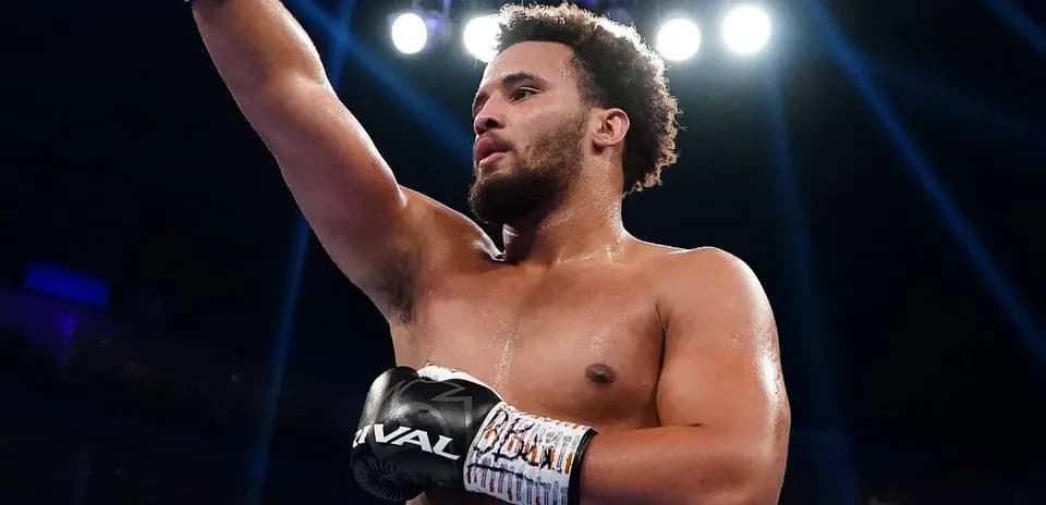 Boxer celebrating victory with raised arm in ring