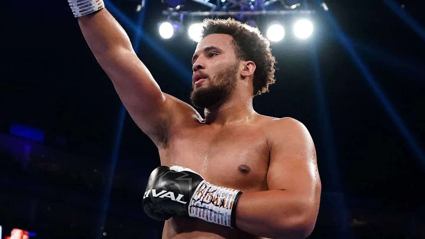 Boxer celebrating victory with raised arm in ring